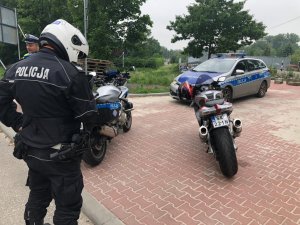 zdjęcie kolorowe: policjanci katowickiej drogówki podczas kontroli drogowej motocyklistów