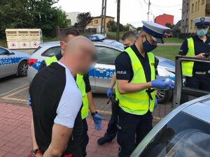 zdjęcie kolorowe: policjanci katowickiej drogówki z zatrzymanym mężczyzną