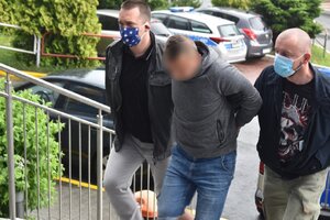 zdjęcie kolorowe: kryminalni katowickiej komendy z zatrzymanym mężczyzną podejrzanym o pedofilię