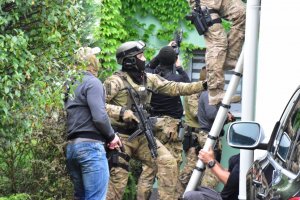 Zdjęcie kolorowe: śląscy kontrterroryści przygotowujący się do wejścia siłowego do domu