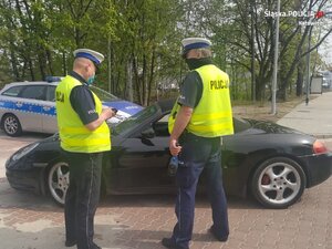 zdjęcie kolorowe: policjanci katowickiej drogówki podczas służby na drodze przy kontroli samochodu