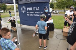 zdjęcie kolorowe: Pierwszy Zastępca Komendanta Miejskiego Policji w Katowicach mł. insp. Artur Orman wręczający nagrodę uczestnikowi