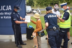 Pierwszy Zastępca Komendanta Miejskiego Policji w Katowicach mł. insp. Artur Orman wręczający dyplom chłopcu