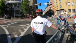 zdjęcie kolorowe: policjant zabezpieczający trasę wyscigu