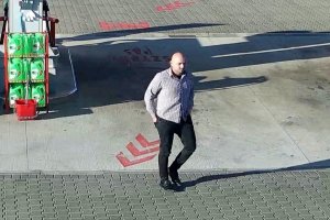 Na kolorowym zdjęciu widać łysego mężczyznę ubranego w białą koszulę i czarne spodnie jest on podejrzaną osobą o dokonanie kradzieży samochodu