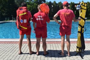 kolorowe zdjęcie: widać trzech ratowników stojących obok basenu