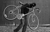 zdjęcie czarno -białe: mężczyzna w kominiarce, który niesie skradziony rower