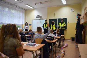 zdjęcie kolorowe: policjanci katowickiej komendy, funkcjonariusze ITD i straży miejskiej podczas spotkania z uczniami i nauczycielem w klasie