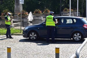 zdjęcie kolorowe: policjanci katowickiej drogówki sprawdzający stan techniczny pojazdu