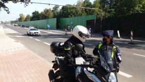 zdjęcie kolorowe: policjantka wydziału prewencji komendy miejskiej Policjia w katowicach podczas rozmowy z motocyklistą w trakcie działań &quot;Road Safety Days&quot;