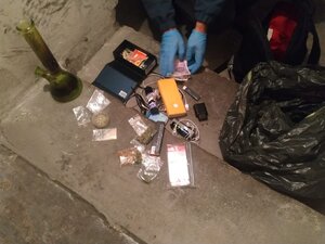 zdjęcie kolorowe: zabezpieczone przez policjantów narkotyki spakowane w woreczki strunowe leżące na schodach piwnicy