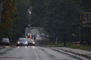 zdjęcie kolorowe: policyjny radiowóz na trasie XII Silesia Marathon jako pilot jadący  przed zawodnikami biorącymi udział w biegu maratońskim