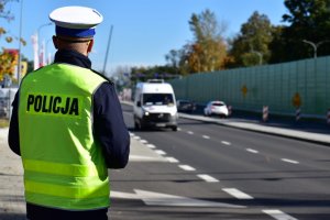 zdjęcie kolorowe: policjant katowickiej drogówki podczas czynności przy drodze w dzielnicy Piotrowice