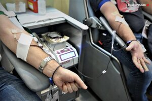 zdjęcie kolorowe: przedramiona dwóch mężczyzn honorowo oddającyh krew