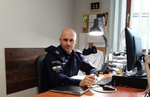 zdjęcie kolorowe: sierżant sztabowy Daniel Radwan, który po ozdrowieniu oddał osocze, siedzący za biurkiem w pracy