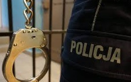 Zdjęcie kolorowe przedstawia policyjne kajdanki na tle napisu Policja.