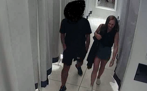 zdjęcie kolorowe: na zdjęciu kobieta wychodząca z przymierzalni, ubrana w ciemna krótka spódniczka i ciemna bluzkę bez rękawów, w towarzystwie mężczyzny