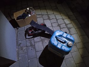 zdjęcie kolorowe: pojemnik z tworzywa sztucznego ze skradzionym paliwem i pudełko kartonowe ze skradzionymi rzeczami