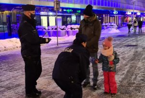 zdjęcie kolorowe: policjant i policjantka z katowickiej komendy rozmawiający z mężczyzną i małym chłopcem