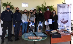 zdjęcie kolorowe: policjanci katowickiej komendy z trzema laureatami konkursu i dyrektorką Zespołu Szkół Poligraficzno – Mechanicznych w Katowicach na szkolnym korytarzu