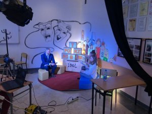 zdjęcie kolorowe: doktor habilitowany Tomasz Huk - dyrektor szkoły w studio szkolnej telewizji dwiema uczennicami przeprowadzającymi wywiad