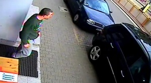 zdjęcie kolorowe: mężczyzna ubrany w zielona bluzę sportowa i szare spodnie na chodniku przed zaparkowanym samochodem