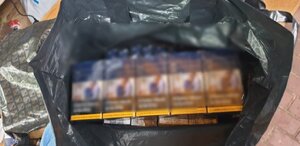 zdjęcie kolorowe: na ladzie czarna reklamówki z "wagonami" papierosów