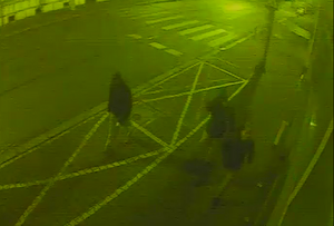 zdjęcie kolorowe: scrren z zapisu monitoringu przedstawiający zamazany obraz trzech męzczyzn