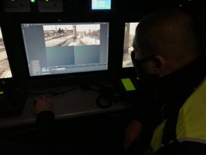 zdjęcie kolorowe: policjant katowickiej drogówki pracujący przy monitorach w Ruchomym Stanowisku Dowodzenia