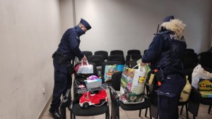 zdjęcie kolorowe: policjant i policjantka z Komisariatu IV Policji w Katowicach pakują zabawki w foliowe torby