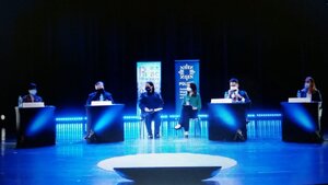 zdjęcie kolorowe: scena w katowickim Pałacu Młodzieży, gdzie na krzesłach siedzi 6 prelegentów