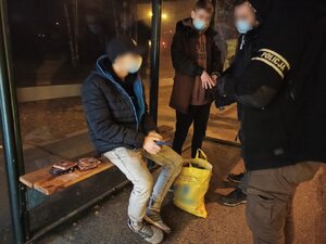 zdjęcie kolorowe: policyjni wywiadowcy na przystanku autobusowym z dwoma zatrzymanymi nastolatkami