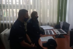 zdjęcie kolorowe: policjant i policjantka wydziału prewencji katowickiej komendy podczas rozmowy on-line z maturzystami