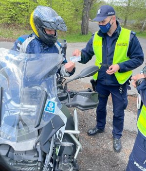 zdjęcie kolorowe: Policjant rozmawiający z motocyklistą podczas działań profilaktycznych