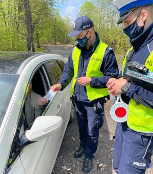 zdjęcie kolorowe: policjanci katowickiej komendy podczas działań profilaktycznych rozmawiający z kierującym samochodem osobowym