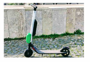 zdjęcie kolorowe: hulajnoga elektryczna zaparkowana na chodniku