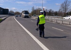 zdjęcie kolorowe: policjant katowickiej drogówki zatrzymujący pojazd do kontroli drogowej