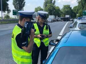 zdjęcie kolorowe: policjanci katowickiej drogówki podczas kontroli drogowej samochodu osobowego