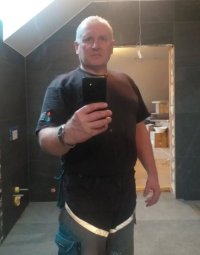 zdjęcie kolorowe: poszukiwany Jacek Jaworek robiący sobie zdjęcie telefonem komórkowym stojąc przed lustrem