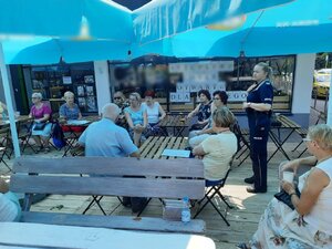 zdjęcie kolorowe: dzielnicowa z Komisariatu VII Policji w Katowicach podczas spotkania z seniorami w letnim ogródku