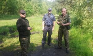 zdjęcie kolorowe: katowicki dzielnicowy ze społecznym strażnikiem rybackim podczas kontroli połowu przez wędkarza