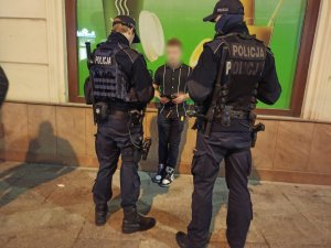 zdjęcie kolorowe: umundurowani policjanci legitymujący osoby w centrum Katowic
