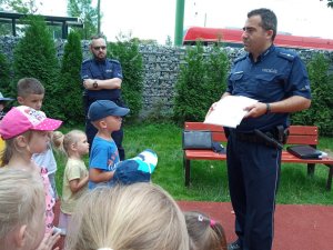 zdjęcie kolorowe: dzielnicowi z komisariatu VII Policji w Katowicach podczas prelekcji z przedszkolakami na placu zabaw