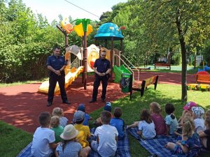 zdjęcie kolorowe: dzielnicowi z komisariatu VII Policji w Katowicach podczas spotkania profilaktycznego z przedszkolakami na placu zabaw