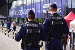 zdjęcie kolorowe: dwóch umundurowanych policjantów przed Międzynarodowym Centrum Kongresowym w którym odbywał się XIII Kongres Gospodarczy