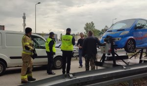 zdjęcie kolorowe: policjanci, strażacy i inspektorzy transportu drogowego przy symulatorze wypadków drogowych