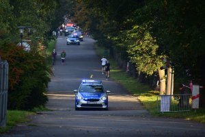 zdjęcie kolorowe: policyjny radiowóz pilotujący uczestników XIII Silesia Marathon, wyjeżdżając z Parku Śląskiego