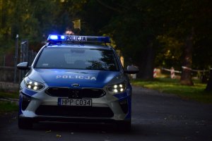 zdjęcie kolorowe: policyjny radiowóz wyjeżdżający z Parku Śląskiego