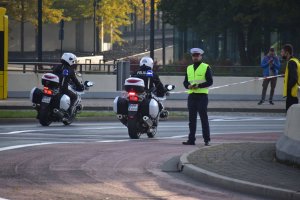zdjęcie kolorowe: policjanci ruchu drogowego na motorach pilotujący uczestników XIII Silesia Marathon w rejonie katowickiego Spodka