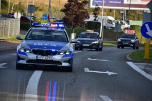 zdjęcie kolorowe: policyjny radiowóz, a także samochody organizatora  pilotujące  uczestników XIII Silesia Marathon